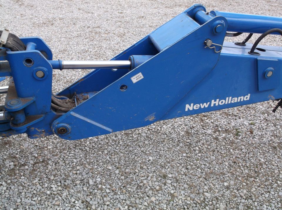 Blue New Holland backhoe attachment with hydraulic cylinder and pins