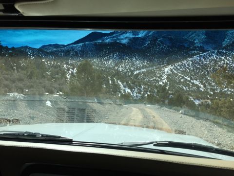 1979 Ford Bronco - Driving on a dirt road through a snow-dusted mountain landscape.