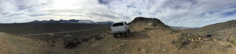 1979 Ford Bronco - A white 1979 Ford Bronco is parked on a dirt trail overlooking a vast, mountainous landscape.