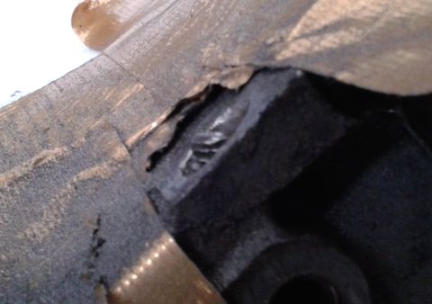 1996 Ford Bronco - A close-up view of a dark, possibly damaged, engine component.