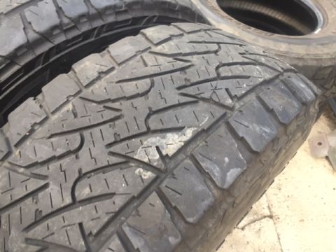 1986 Ford Bronco - A close-up view of tire treads, with another tire stacked behind it.