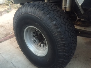1986 Ford Bronco - Close-up of a BFG All-Terrain KO tire and wheel, part of a vehicle's suspension system is visible.