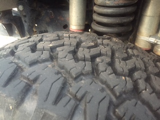 1986 Ford Bronco - Tire tread detail with suspension components visible.