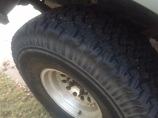 1986 Ford Bronco - Close-up of a tire and wheel with a SuperMotors logo visible on the tire.
