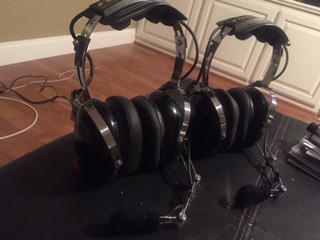 1986 Ford Bronco - Two pairs of noise-canceling headphones are displayed on a mat in front of a white cabinet.