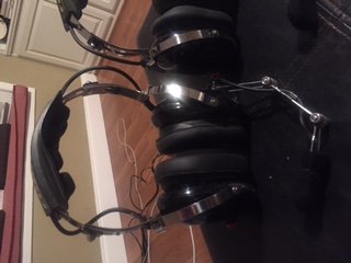 1986 Ford Bronco - Two pairs of black headphones with chrome accents and adjustable booms are shown.