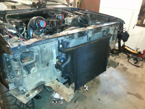 1994 Ford Bronco - Custom engine modification twin turbochargers and an oversized intercooler in a vehicle's engine bay.