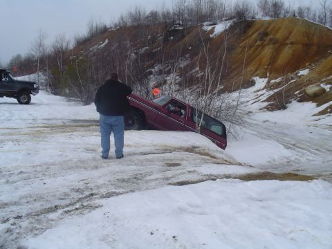 1993 Ford Bronco - A maroon 1993 Ford Bronco is stuck in the snow on a hill, while another vehicle waits nearby.