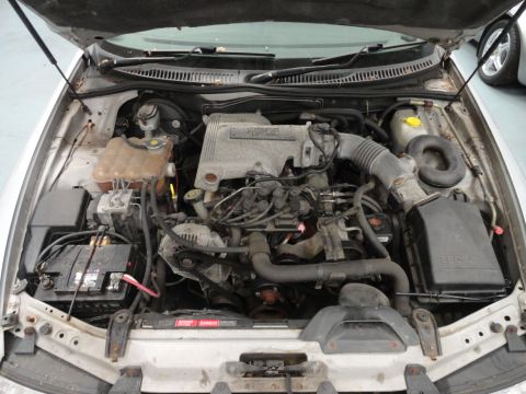 1999 Ford Fairlane - The engine compartment of a car is shown with the hood raised, revealing the engine and various components.