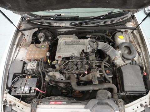 1999 Ford Fairlane - The engine bay of a vehicle is shown with the hood open, revealing the engine components and V6 4.0L badging.
