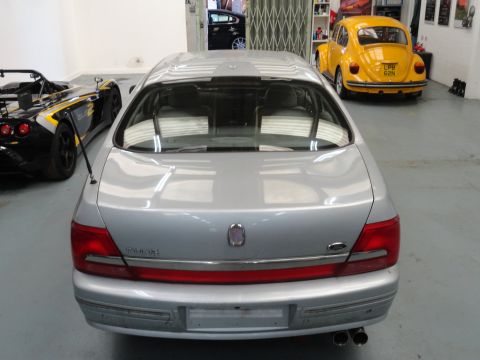 1999 Ford Fairlane - Rear view of a 1999 Ford Fairlane parked indoors with other vehicles.