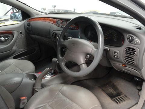 1999 Ford Fairlane - The interior of a car is shown, leather seats and a wood-grain trim on the dashboard.