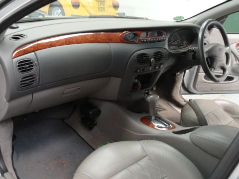 1999 Ford Fairlane - The interior of a 1999 Ford Fairlane shows wood grain accents on the dashboard and center console.