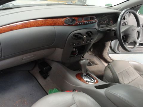 1999 Ford Fairlane - The interior of a car shows the dashboard, center console, and seats. The registry claims it is a 1999 Ford Fairlane, but this is not evide…