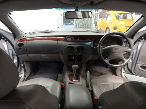 1999 Ford Fairlane - Interior view of a 1999 Ford Fairlane, with a yellow Volkswagen Beetle seen in the background.