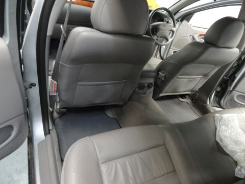 1999 Ford Fairlane - The interior of a car is shown, gray leather seats and a view of the dashboard and steering wheel.