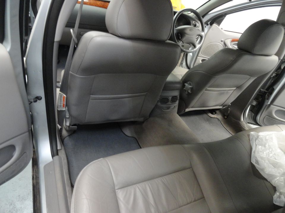 Interior view of a car showing front and rear seats, dashboard, and steering wheel