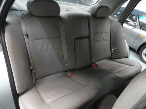 1999 Ford Fairlane - The interior of a car's back seat is shown, with another vehicle visible through the window.