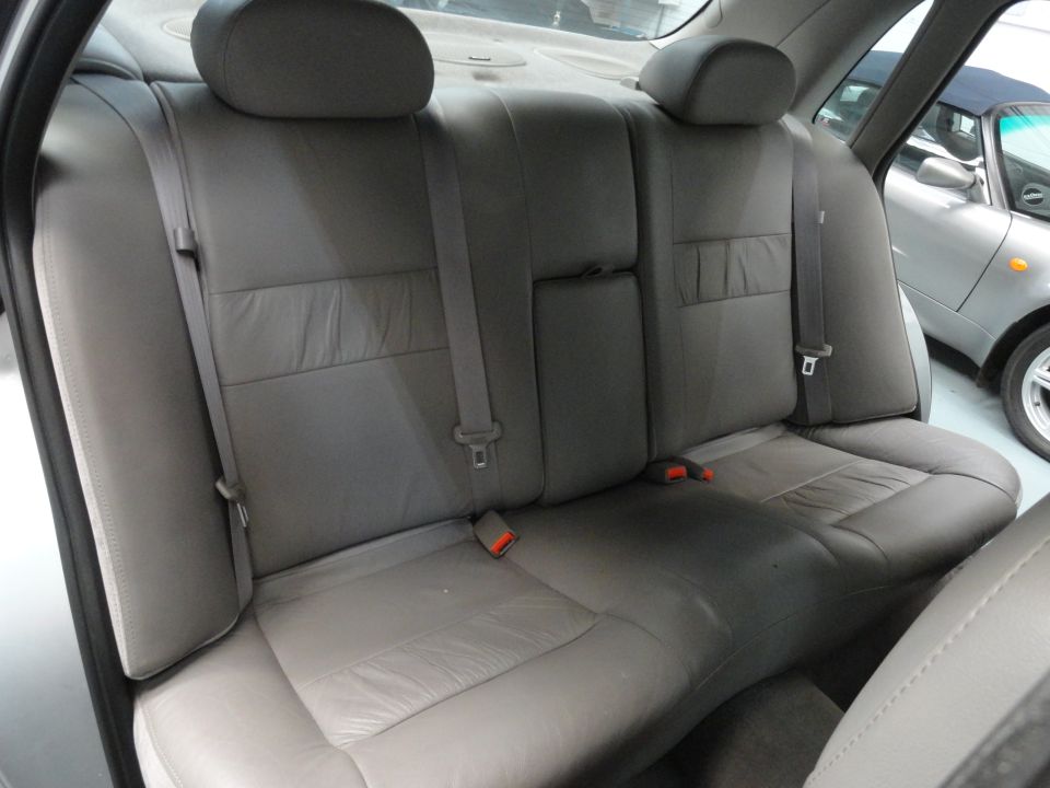 Back seat of a car, gray leather. Another car is visible outside the window