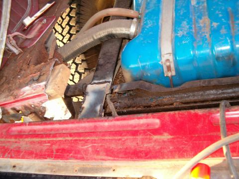 1979 Ford Bronco - The interior of the vehicle shows extensive rust and damage, with a prominent blue fuel tank visible.