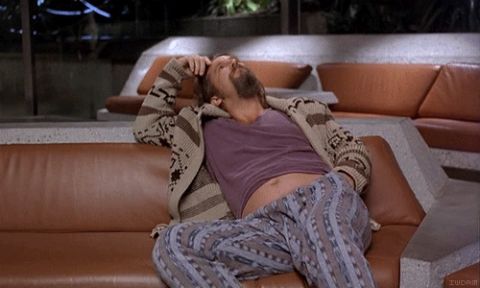1995 Mercury Grand Marquis - A man in pajamas and a cardigan is lying on a couch with his hand on his head.
