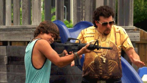 1995 Mercury Grand Marquis - Two men are on a playground with one holding a rifle and the other gesturing.