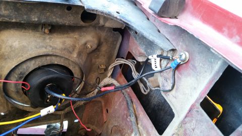 1981 Ford Bronco - Close-up view of wiring and a headlight assembly in the engine bay of a vintage Ford Bronco. The wiring appears to be a custom modification…