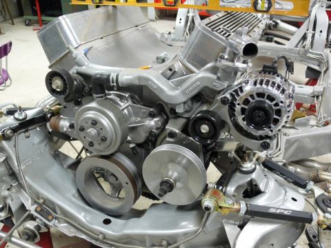 Silver engine assembly with SPC suspension components in a vehicle frame.