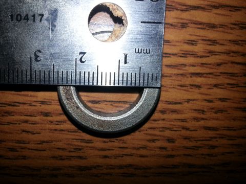 1994 Ford Bronco - A metal ruler is placed over a metal ring, with the ruler's markings indicating a measurement. The ring appears to be a part of a larger ob…
