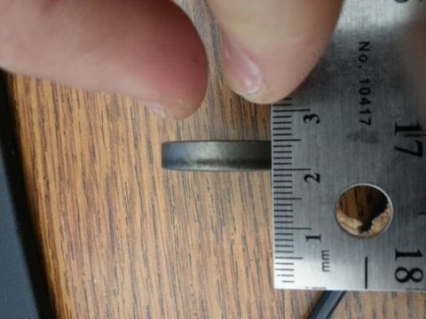 1994 Ford Bronco - A ruler is shown measuring the thickness of a metal ring. The ruler has markings in millimeters and inches, with the measurement appearing…