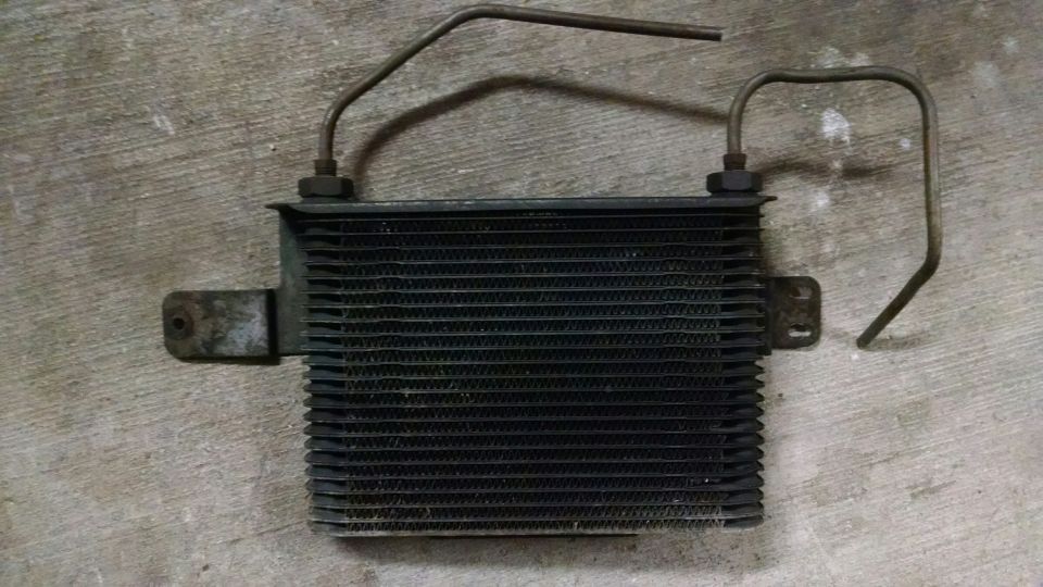 Transmission cooler with metal lines and mounting brackets on concrete