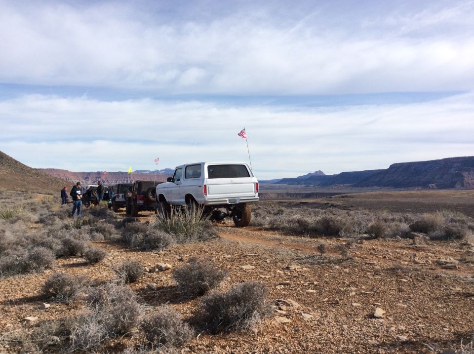 White 1979 Ford Bronco with an American flag in a desert landscape.