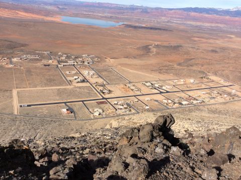 1979 Ford Bronco - An aerial view shows a developing residential area in a desert landscape with a body of water in the distance.
