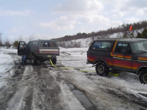 1993 Ford Bronco - Two Ford Broncos are seen in a snowy landscape, with one vehicle being towed by the other.