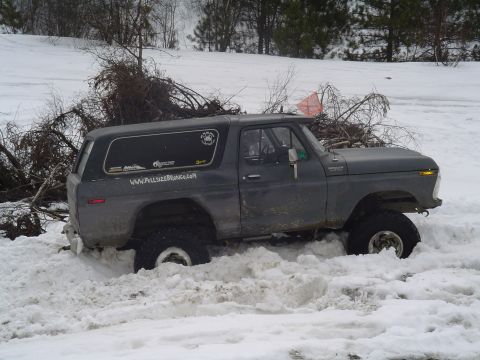 1993 Ford Bronco - This classic Ford Bronco is deep in the snow, with a pile of branches on its roof.