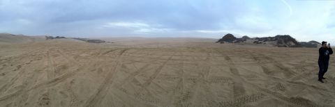 1989 Ford Bronco - A wide panoramic view of a sandy terrain with numerous tire tracks, suggesting off-road activity.