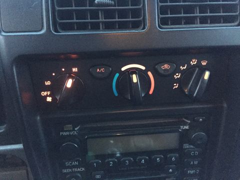 1989 Ford Bronco - The climate control knobs and radio are visible in this interior shot of a vehicle.