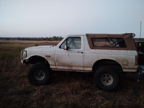 1992 Ford Bronco - This 1992 Ford Bronco is shown in profile, its white paint covered in mud from off-road use.