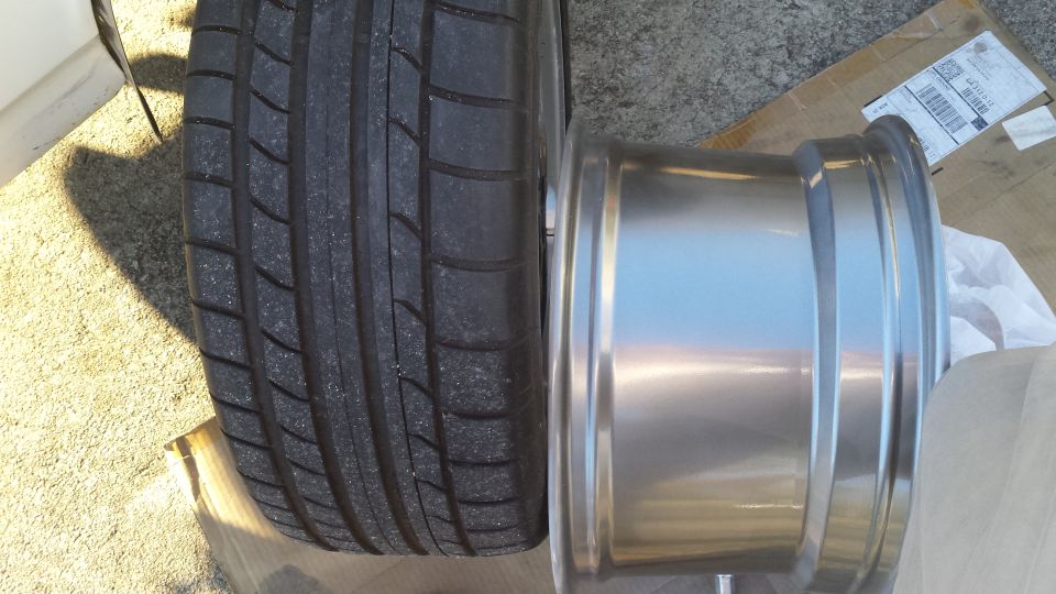Tire next to a shiny metal wheel rim