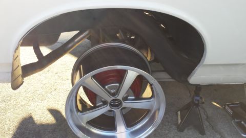 1976 Ford Ranchero - Rear wheel well showing brake assembly and a spare wheel. Vehicle is on jack stands.