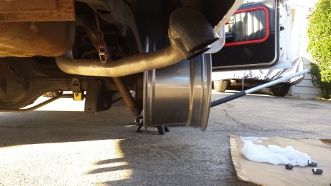 1976 Ford Ranchero - The rear wheel has been removed from the vehicle, exposing the exhaust system and suspension components for maintenance.