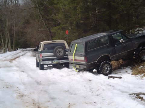 1993 Ford Bronco - Two Ford Broncos navigate a snowy landscape, with one assisting the other.