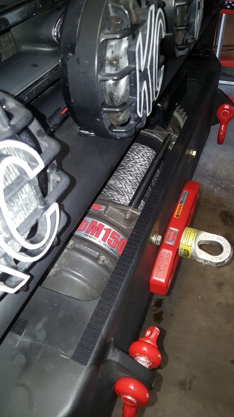 1996 Ford Bronco - A vehicle's front bumper is equipped with a winch and KC auxiliary lights.