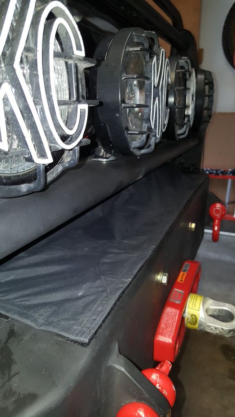 1996 Ford Bronco - Close-up of KC lights and a winch attached to a vehicle's bumper.