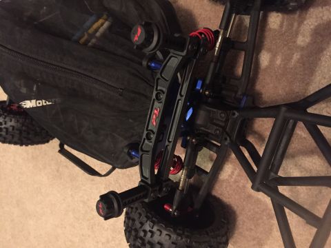 2014 Dodge 1500 - Close-up view of a black remote control car chassis, red shocks and blue suspension components.