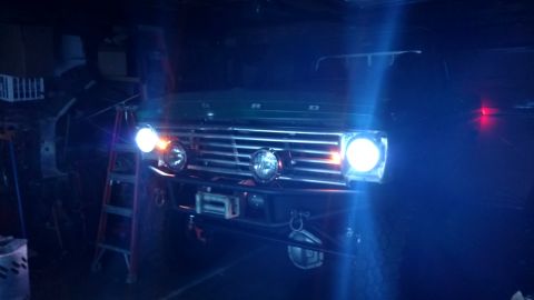 1967 Ford F-250 - Front view of a 1967 Ford F-250, its grille, headlights, and a winch, illuminated in a dark setting.