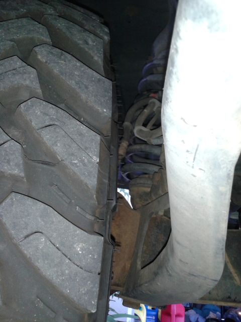 1996 Ford Bronco - Detail shot of a vehicle's tire and suspension components, focusing on the wheel well area.