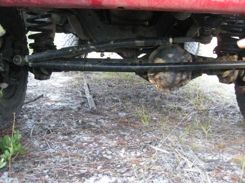 1994 Ford Bronco - Undercarriage view of a red vehicle, showing suspension and steering components.