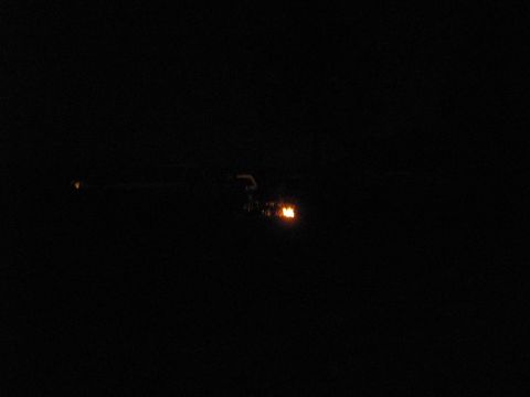 1994 Ford Bronco - A vehicle is barely visible in the dark, with only its headlights providing illumination.