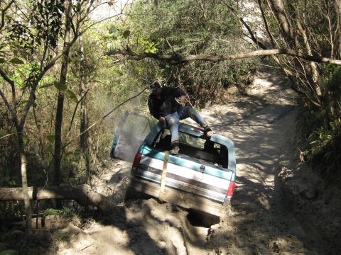 1994 Ford Bronco - A teal 1992 Ford Bronco is stuck in a muddy off-road trail, with a person exiting through the rear door.